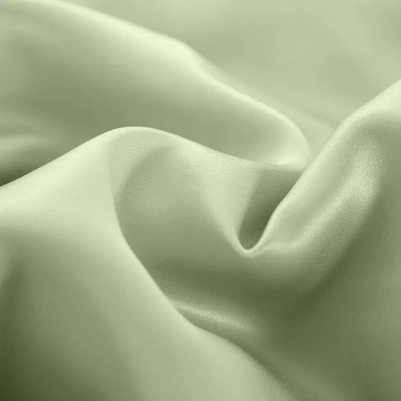 Pure silk duvet cover in a solid colour showing its sheen and texture, laid flat on a bed.
