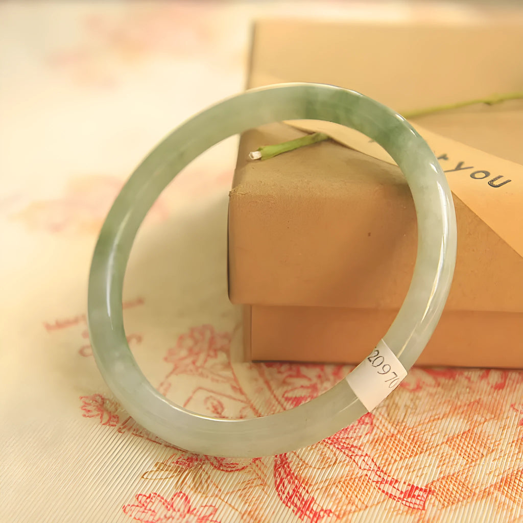 Green geometric Chinese style jade waxy bracelet shown on a wrist, highlighting its 10mm width and detailed pattern.