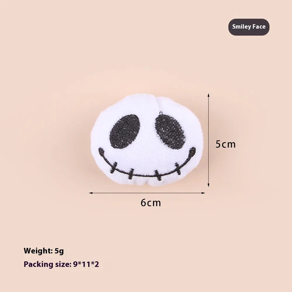 Small plush cat teaser wand with three interchangeable attachments: candy, eyes and skull designs
