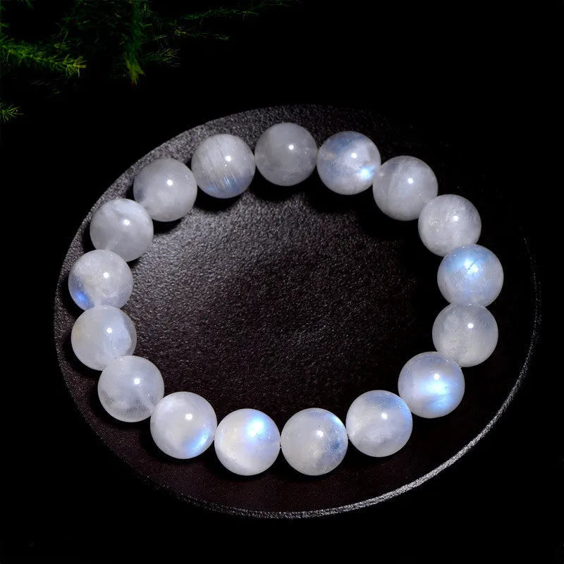 Natural blue moonlight round bead bracelet made from polished moonstone stones on a wrist.