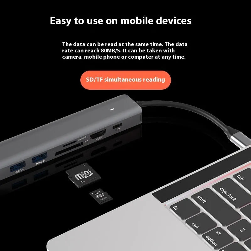 Silver USB C 7-in-1 hub dongle with SD card slot, micro SD slot, and USB C PD charging port.