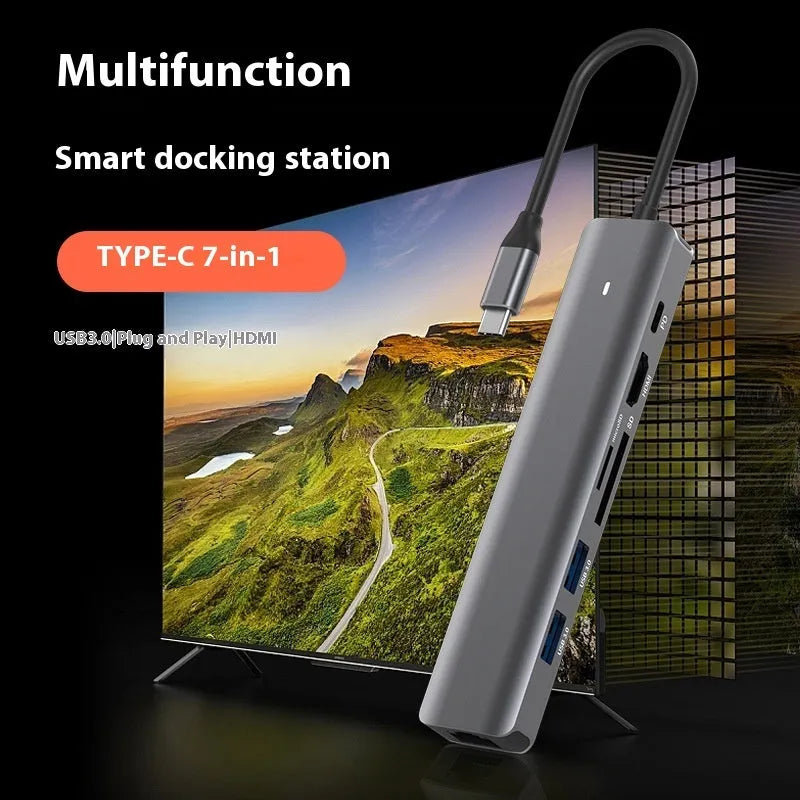 Silver USB C 7-in-1 hub dongle with SD card slot, micro SD slot, and USB C PD charging port.