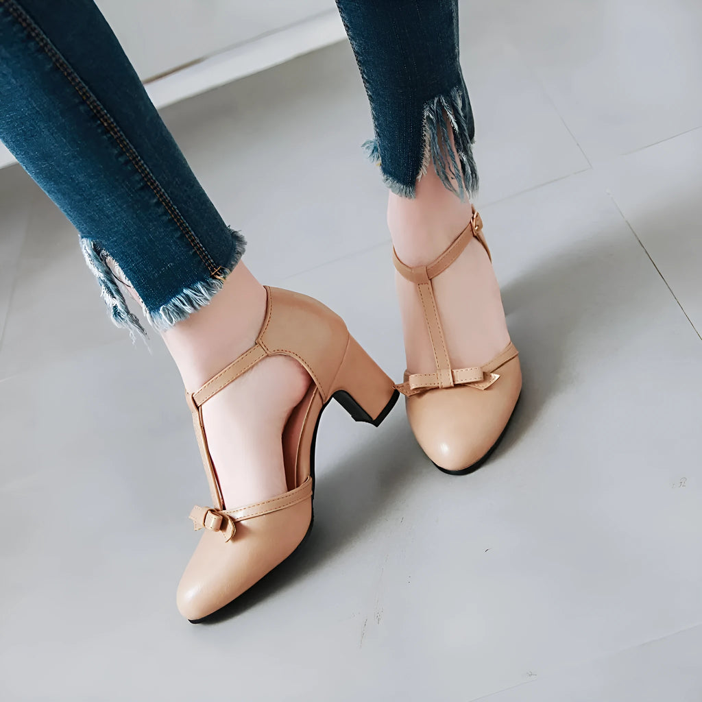 Women's solid colour sandals with chunky heel, hollow out pattern, and a bow tie on the strap.