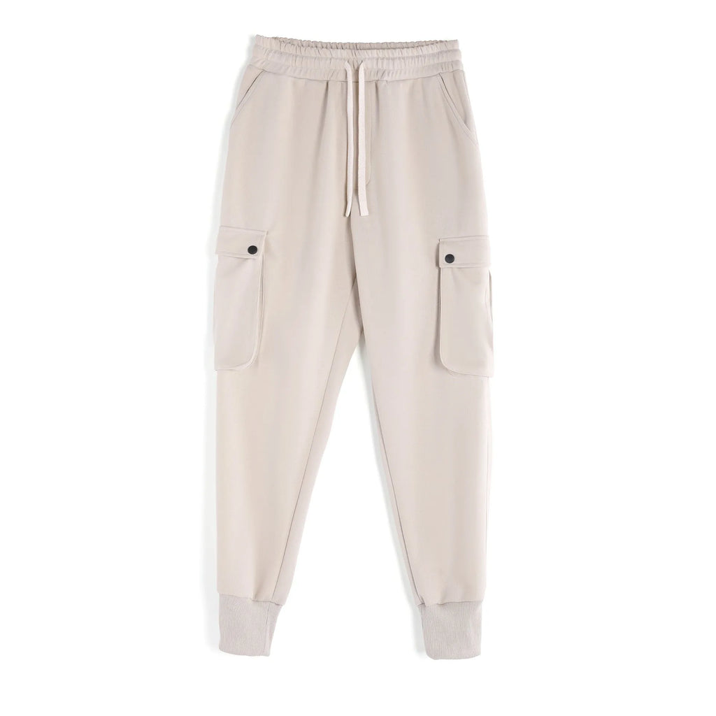 Men's loose light grey cotton sports trousers with ankle ties and multiple pockets laid flat.