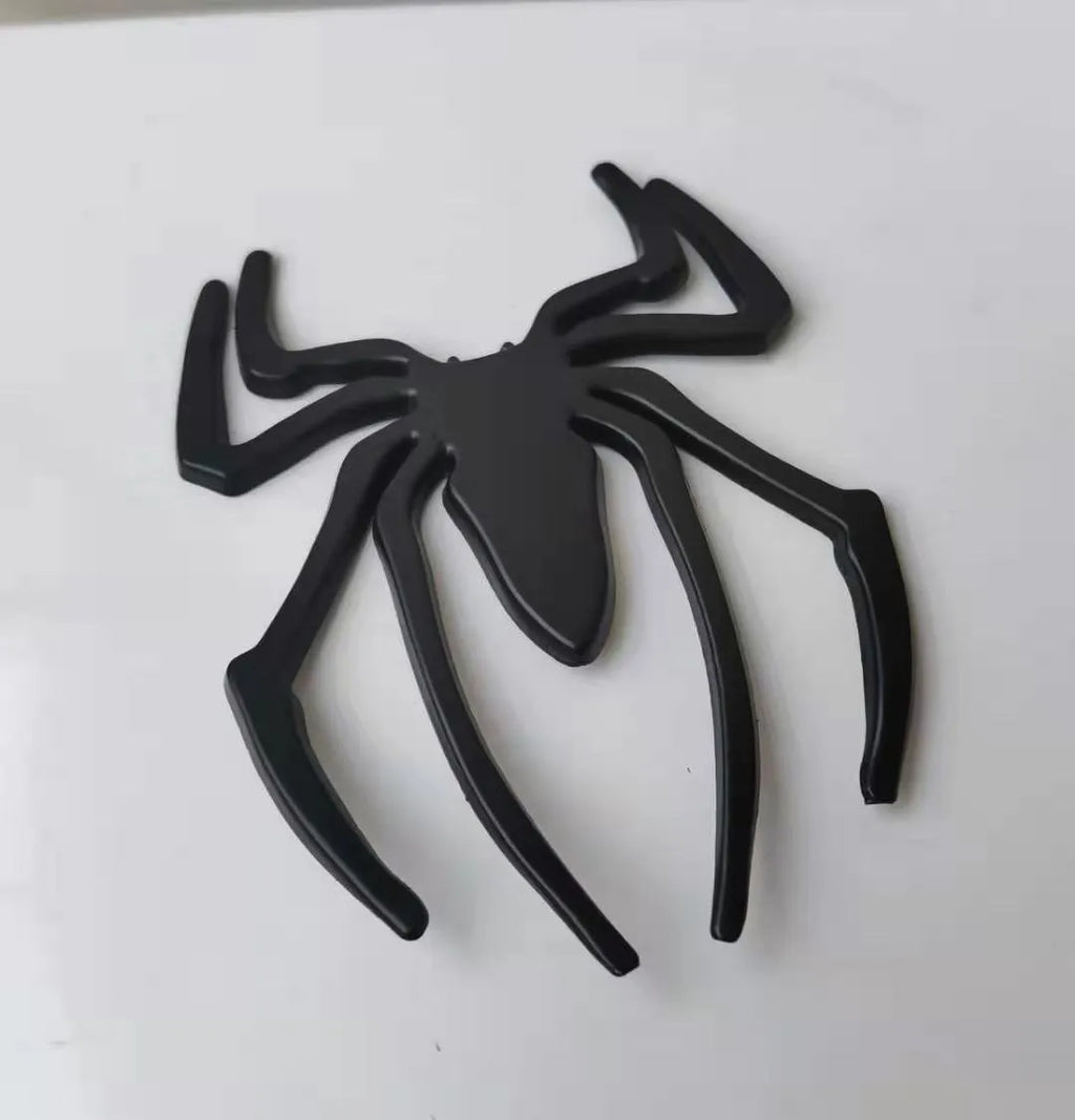 Gold 3D metal spider bumper sticker on a car bumper