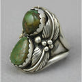Close-up of a women's geometric retro ring with an inlaid turquoise stone on an alloy band.