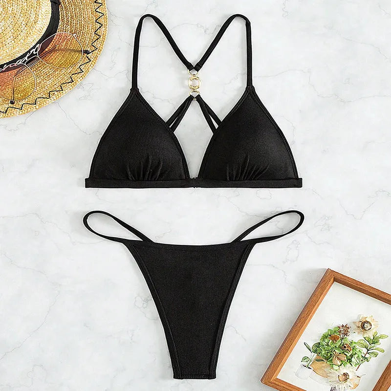 Black women's bikini set with open back triangle top and low-rise pants on a mannequin.