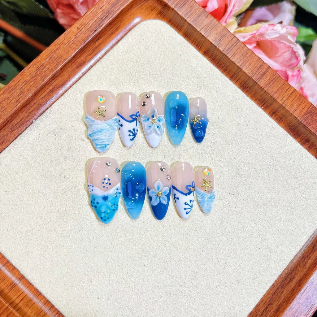 Blue hand-painted carved plastic fake nails set in sizes XS, S, M, L.