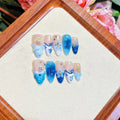 Blue hand-painted carved plastic fake nails set in sizes XS, S, M, L.