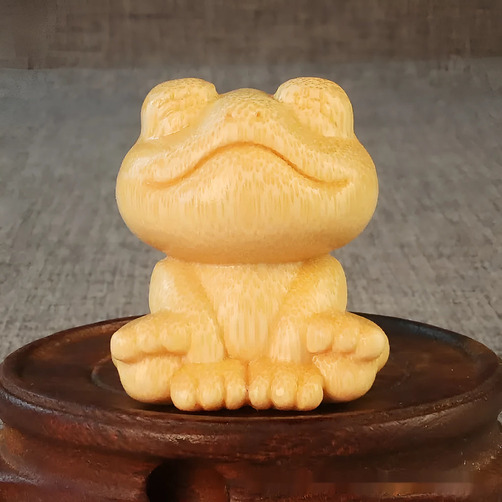 Solid bamboo carving ornament of a smiling cartoon frog, 5 cm tall.