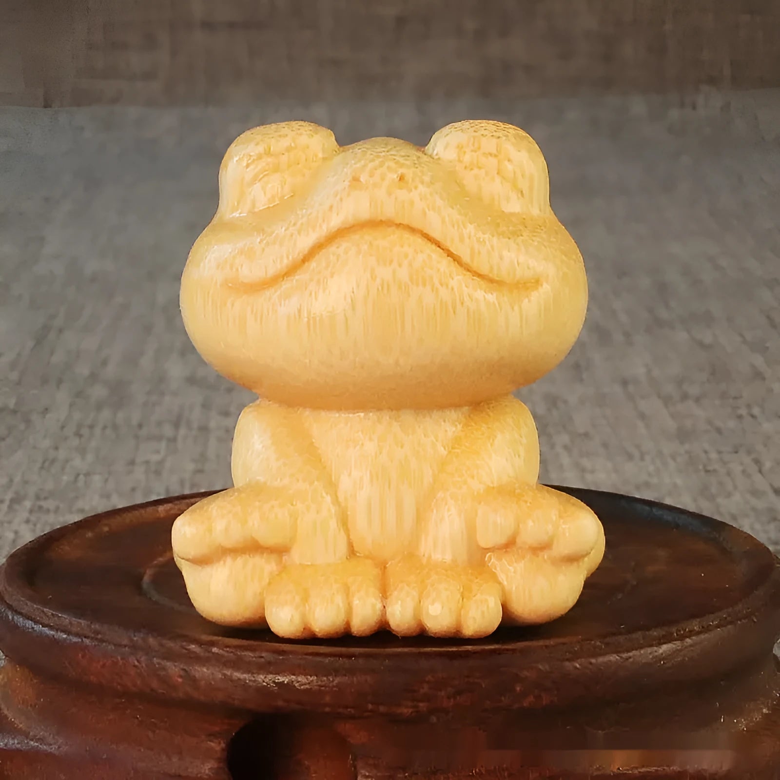 Solid bamboo carving ornament of a smiling cartoon frog, 5 cm tall.