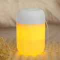 White cylindrical mini humidifier with USB cable on wooden desk