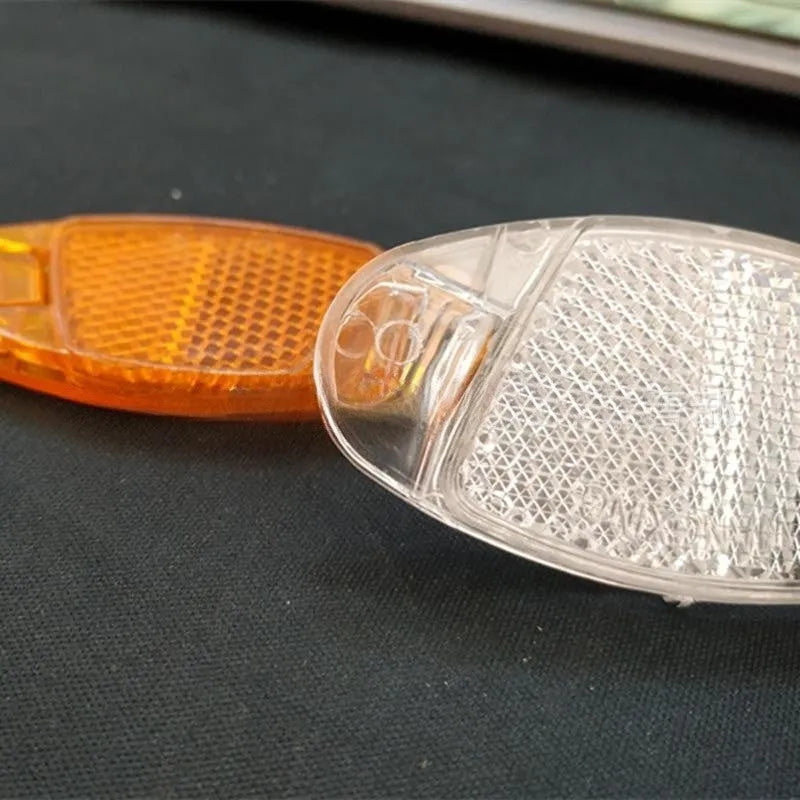 White and yellow plastic bicycle spoke reflector discs for night safety warning
