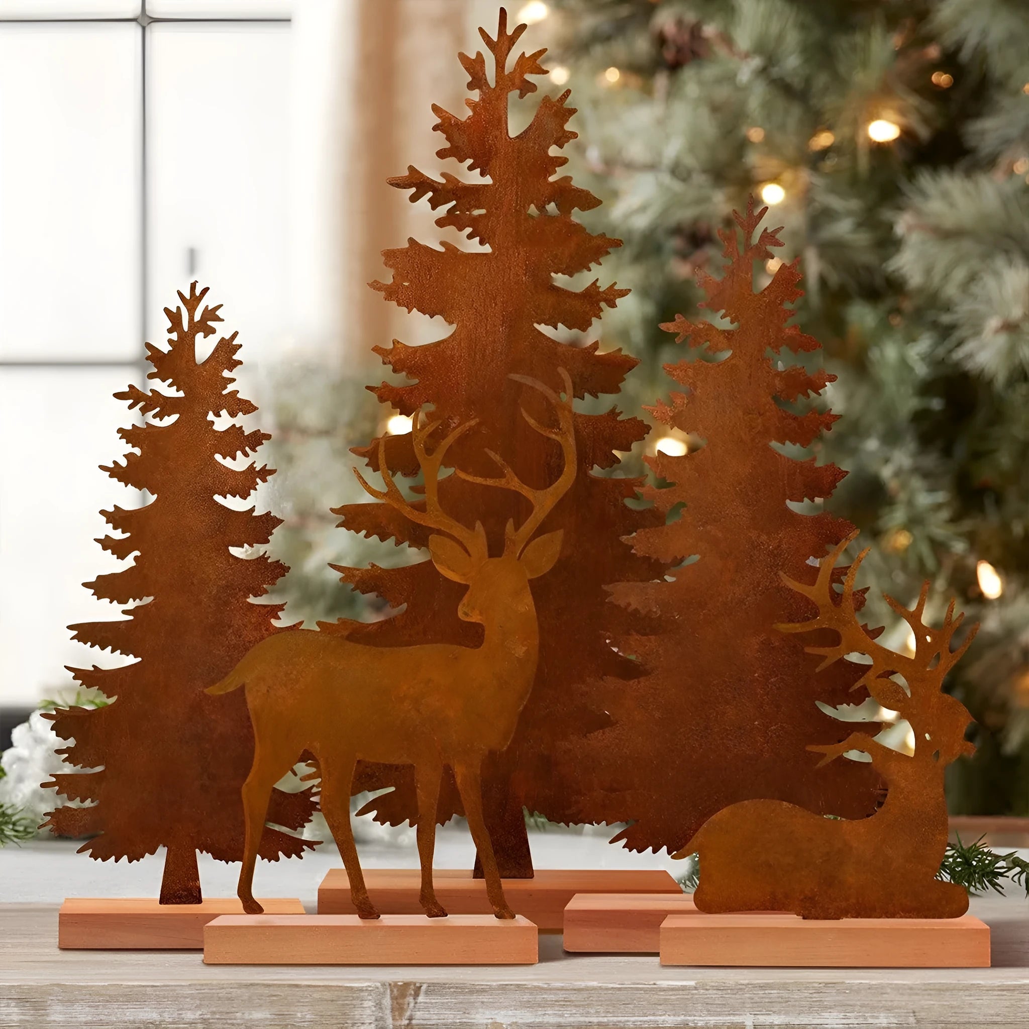 Set of three rusty metal Christmas tree decorations with elk silhouettes on a rustic surface.