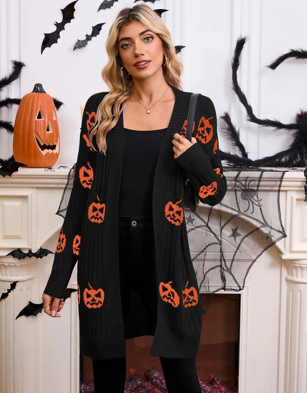 Women's black Halloween cardigan with orange pumpkin head jacquard pattern, shown as a straight-cut medium-length knit.