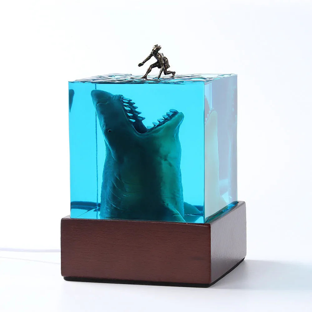 Epoxy resin shark surf scene night light ornament in 5cm and 8cm sizes on a table.