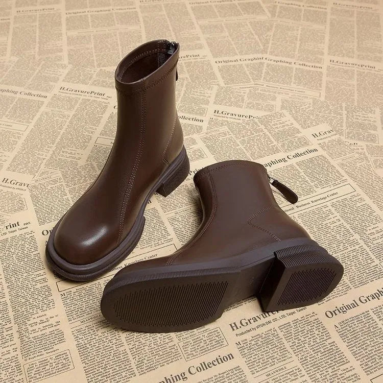 Women's black ankle boots with a flat thick heel, round toe, and a back zip fastener.