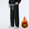 Men's apricot fleece-lined loose-fit sports casual trousers with elastic waist on a hanger.