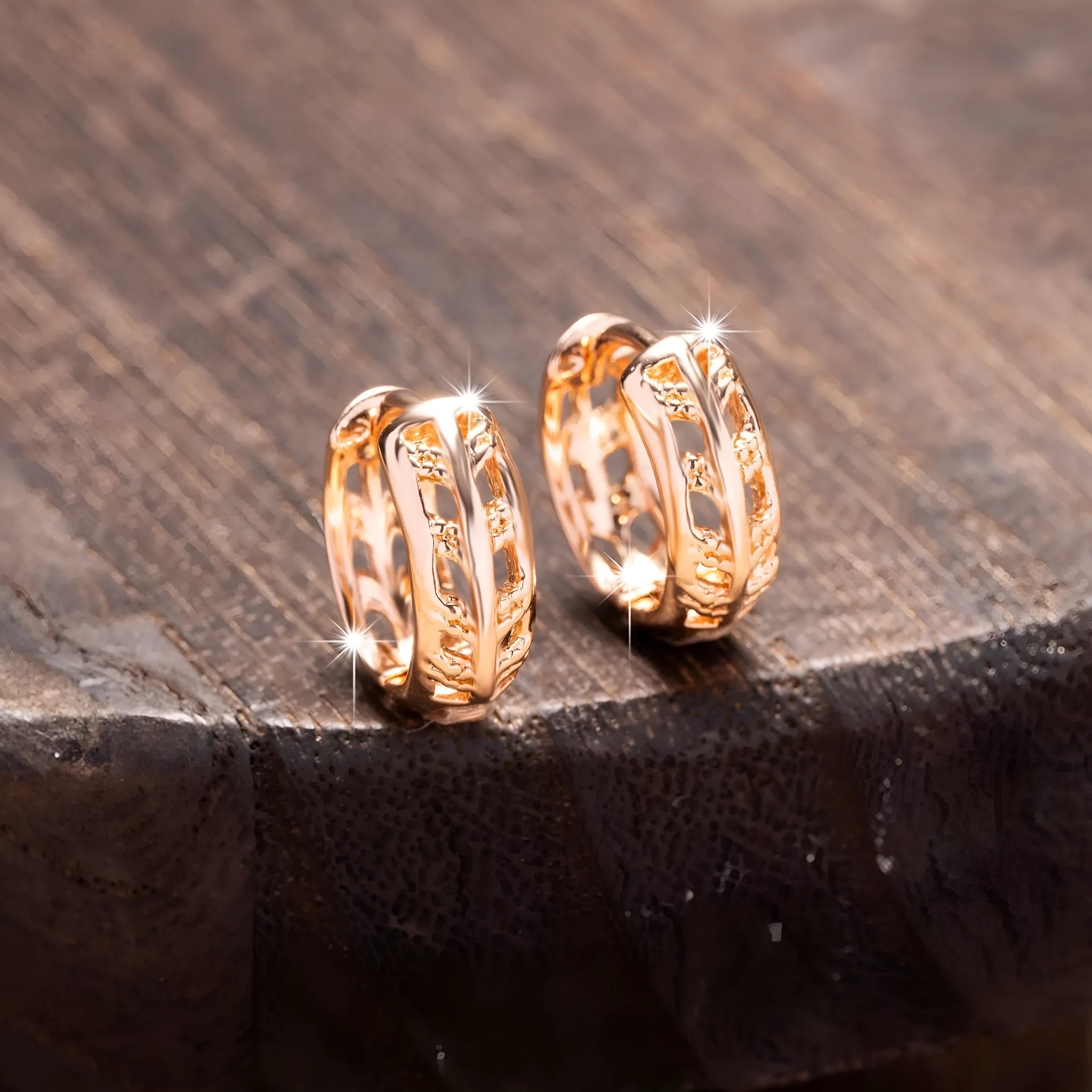 Rose gold coloured copper earrings with a hollowed leaf design and small heart detail.
