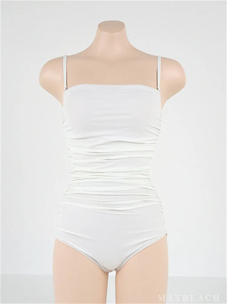 Blue one-piece swimsuit with sling neckline and pleating detail across the belly.