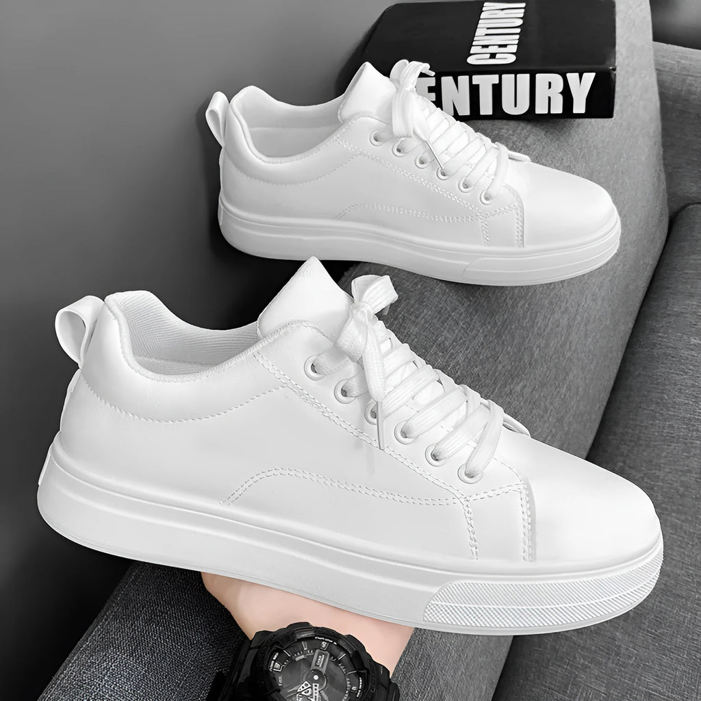 Men's low-top casual sneakers in white, black, or black with white sole, showing round toe and flat rubber sole.