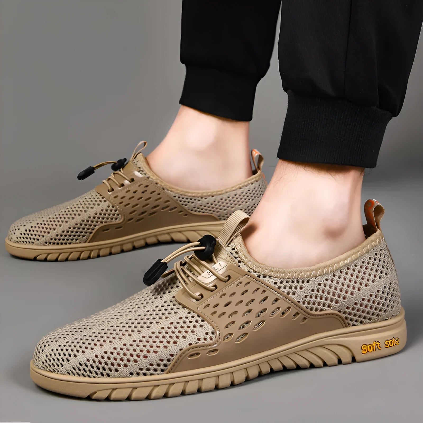 Men's black mesh casual sports shoe with elastic band fastening and rubber sole, shown on a white background.