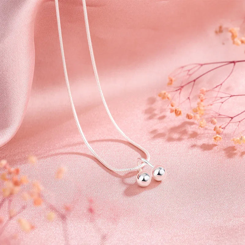 Silver cherry necklace for women with fruit pendant on a snake bone chain, adjustable length.
