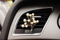 Alloy cartoon car air vent fragrance clip in one of twelve decorative styles.