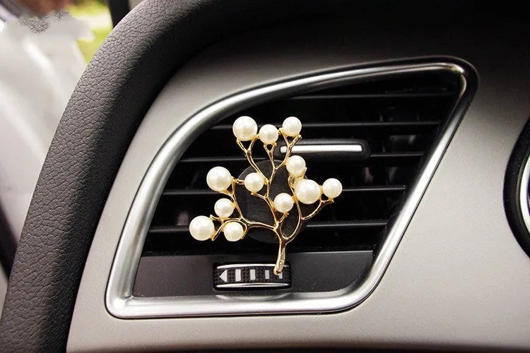 Alloy cartoon car air vent fragrance clip in one of twelve decorative styles.