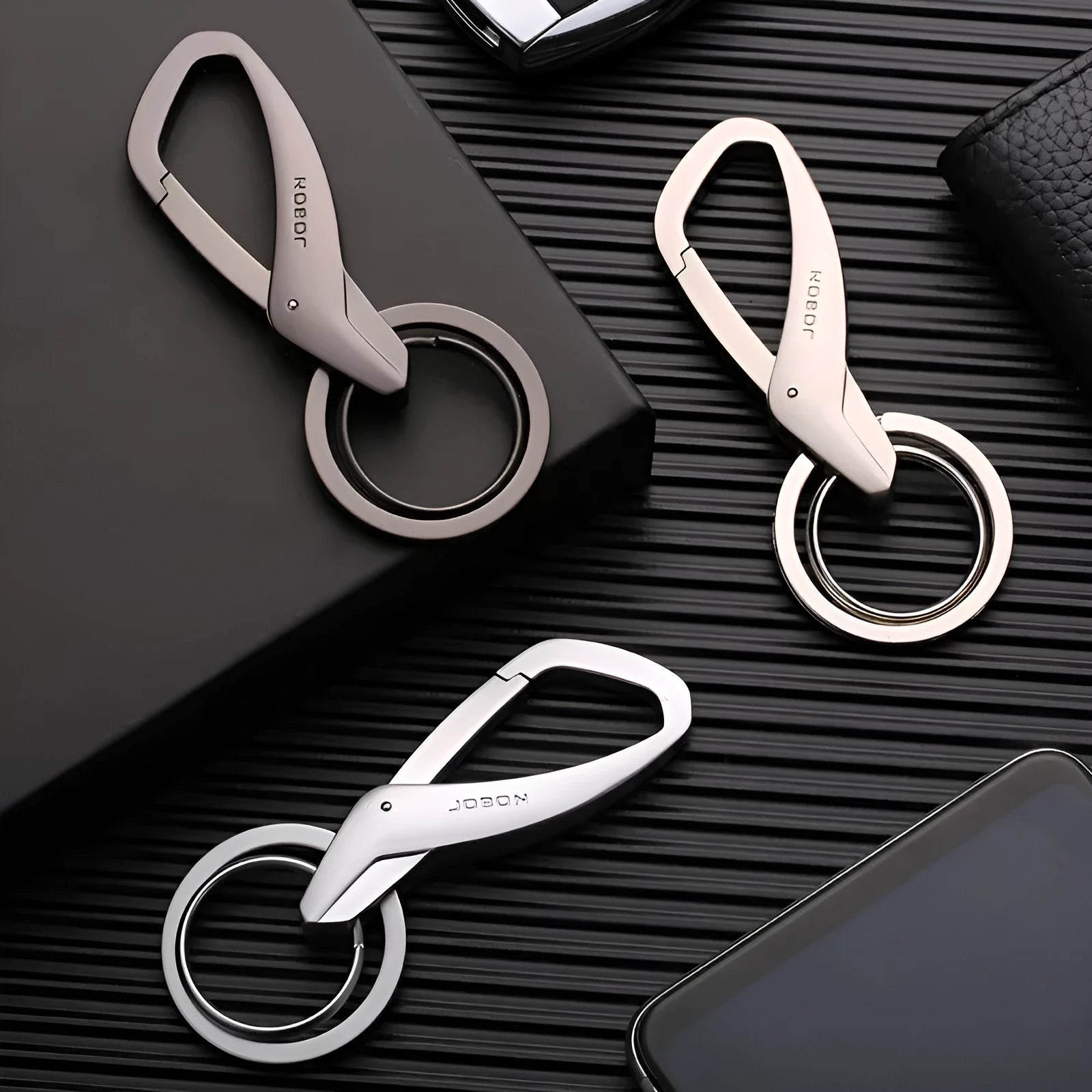 Modern zinc alloy double ring car keychain in black, chrome, and nickel colours showing its 8.3cm by 3.5cm size.