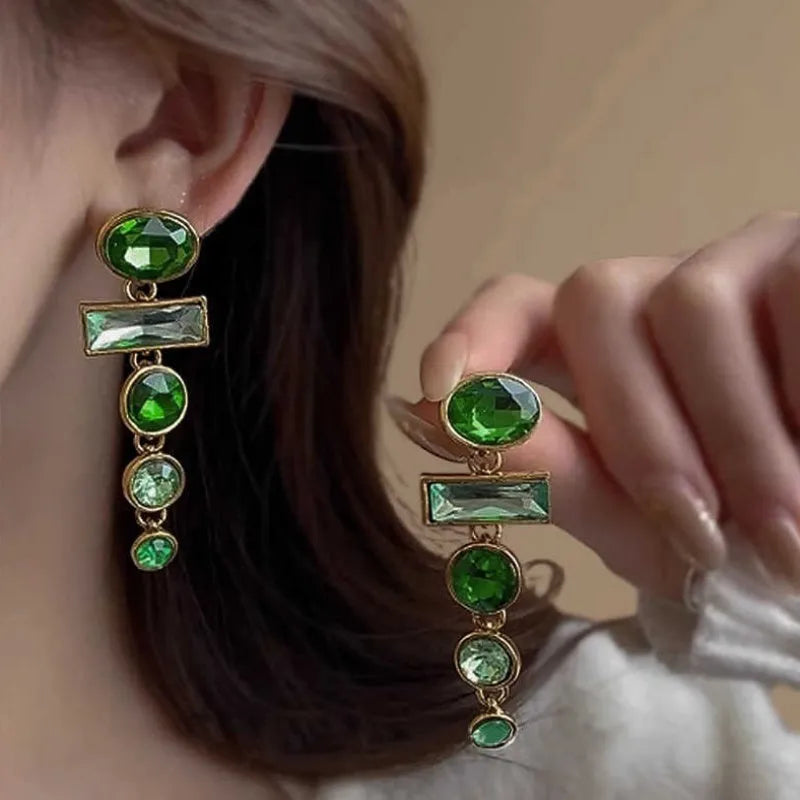 Close-up of green gradient geometric alloy earrings with long tassels and sparkling inlaid zircons.