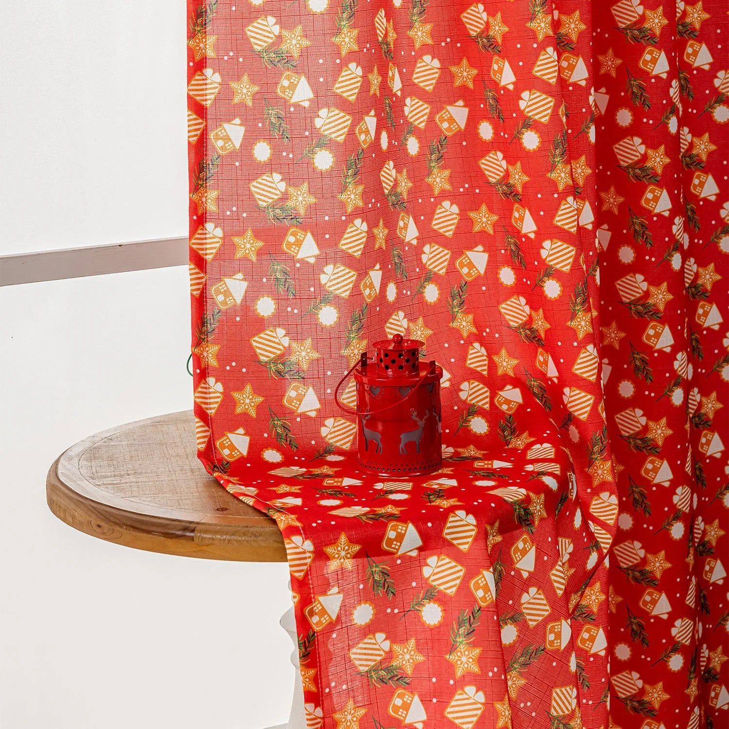 Green festive curtain with printed cartoon snowman and angel pattern.