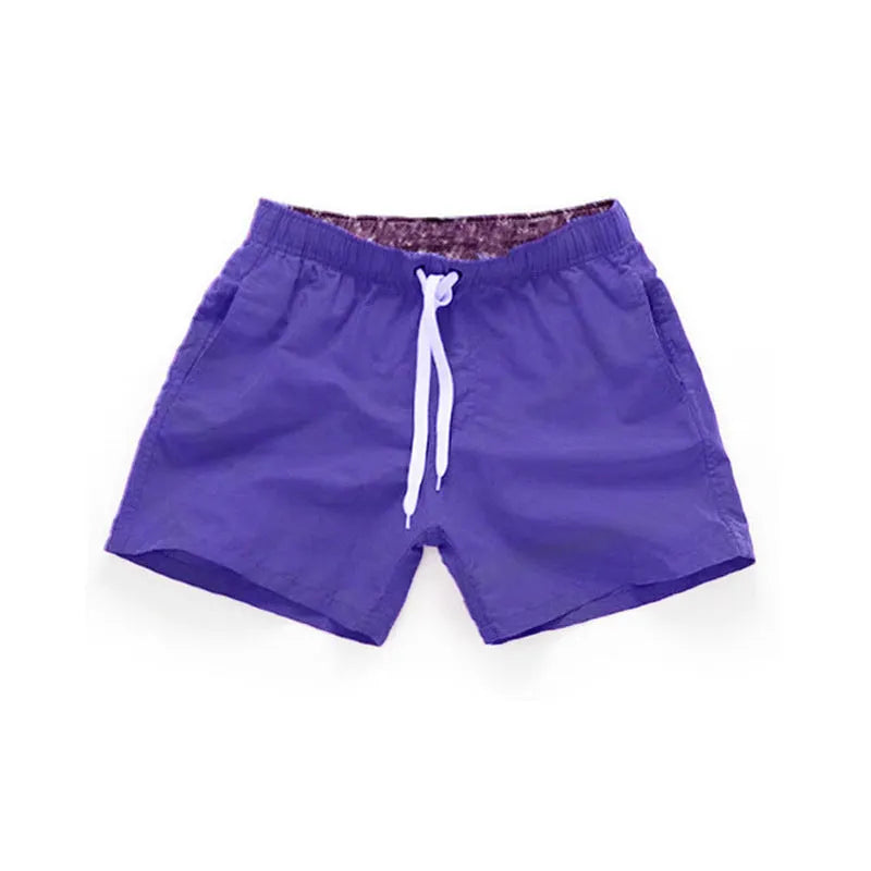 Men's straight leg beach shorts in polyester, shown in multiple colours including fluorescent yellow and navy blue.