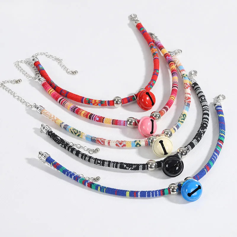 Adjustable ethnic pattern pet collar with a bell, shown in various colours for cats and small dogs.