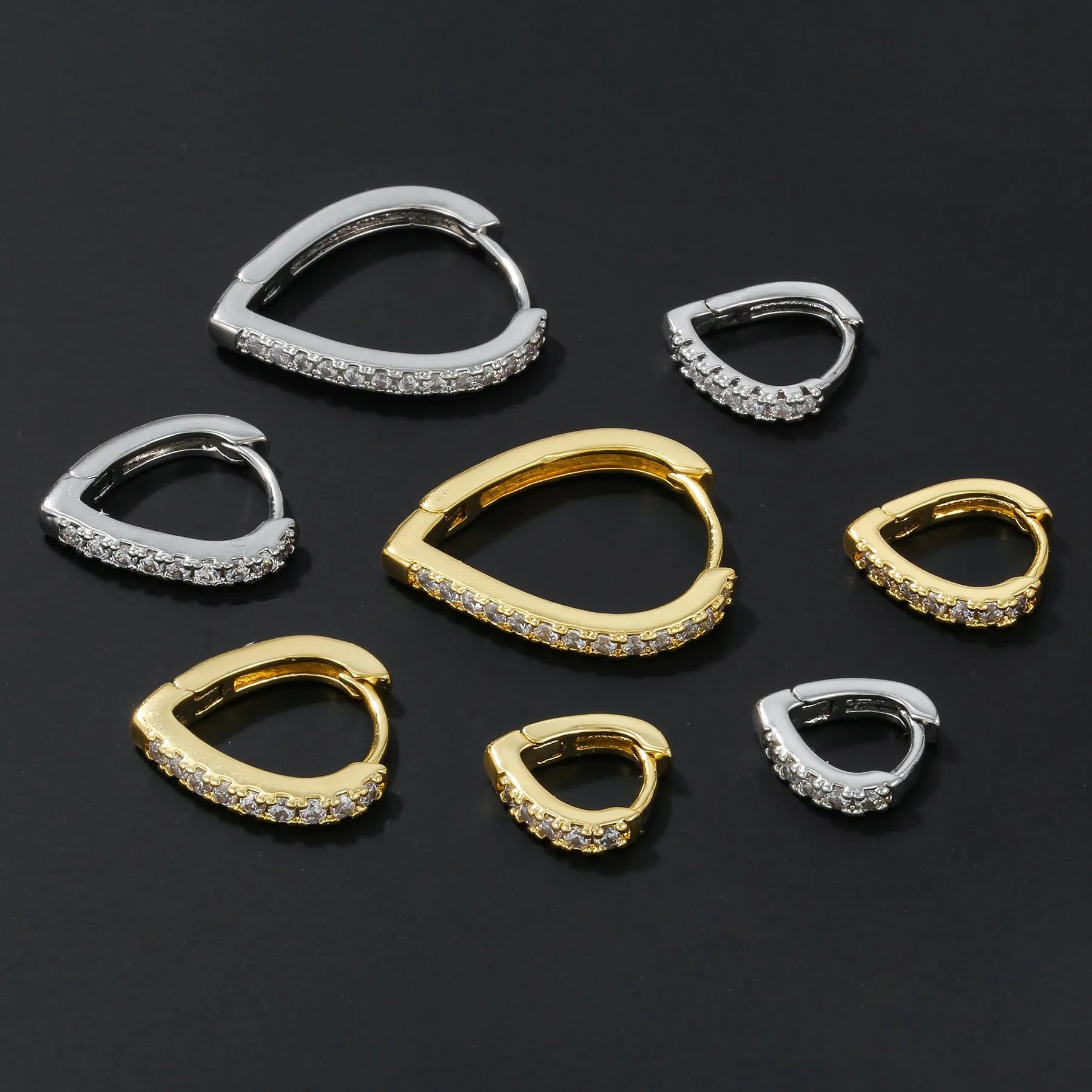 A geometric heart-shaped copper ear clip with a gold or white electroplated finish.