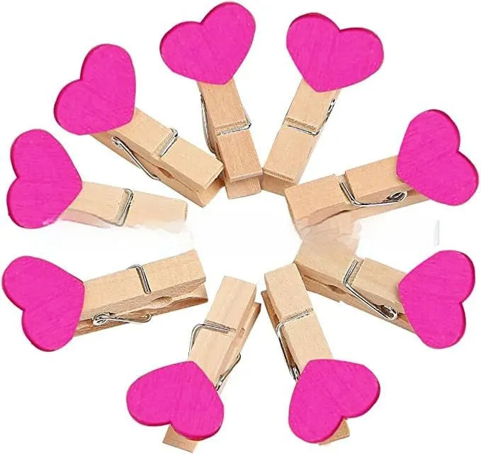 Five solid wood heart-shaped clips in red, rose red, and white colours on a natural background.