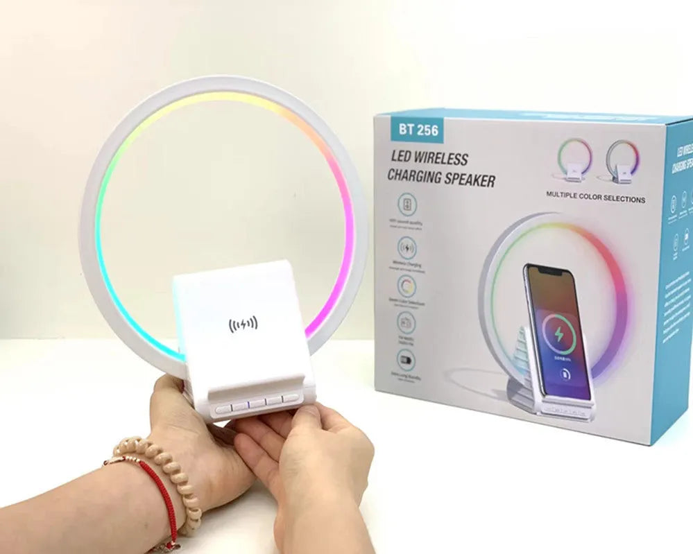 White rectangular smart device combining a wireless charging pad, Bluetooth speaker, and ambient light panel.