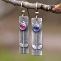 A pair of antique finish red sapphire geometric drop earrings with an elliptical design in a retro style