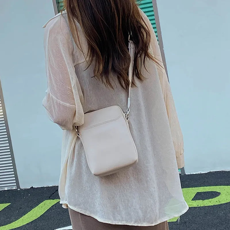 Small solid colour crossbody shoulder bag for women, shown in beige.