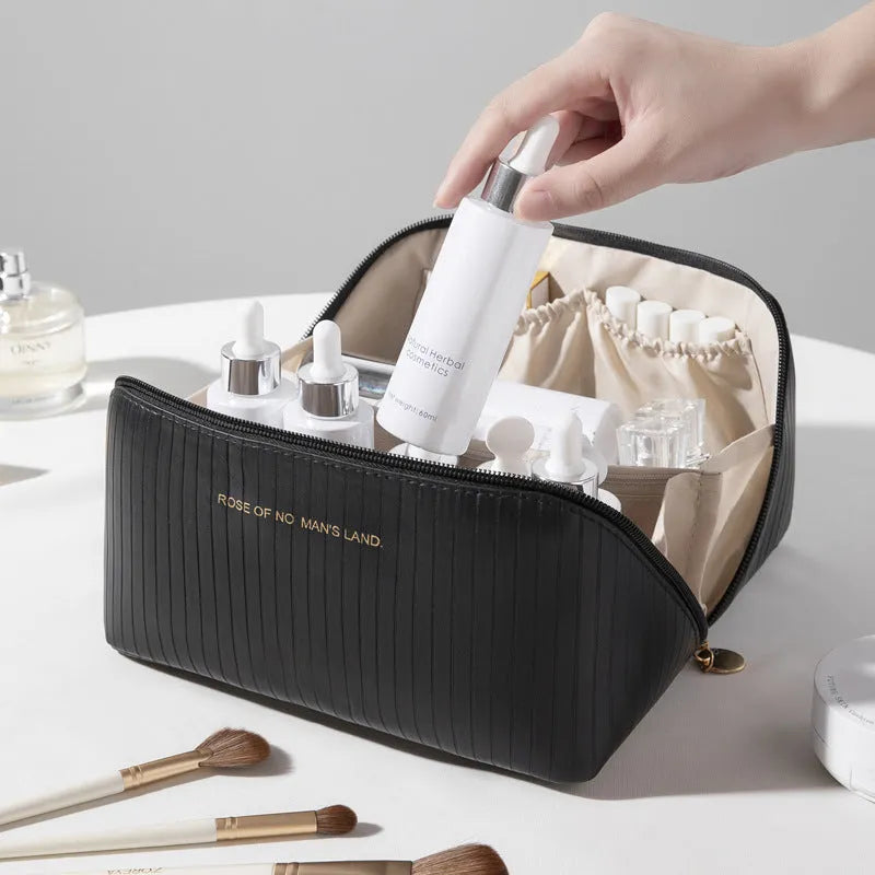 Cubic pillow-shaped PU makeup bag in a vertical pattern, shown in one of five colours: beige, black, brown, grey, or pink.