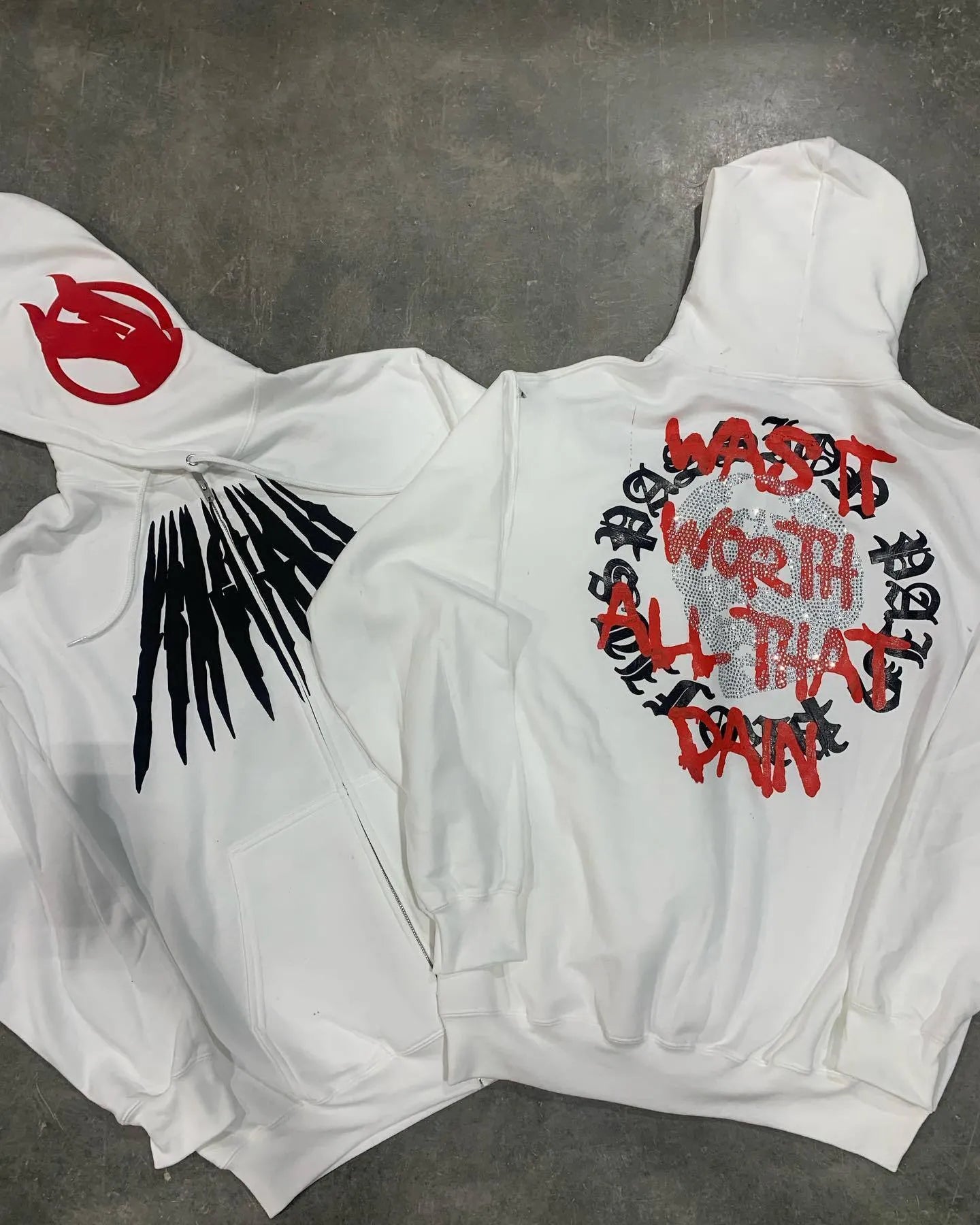 Black loose hooded sweatshirt with white skull print and rhinestone details on the front
