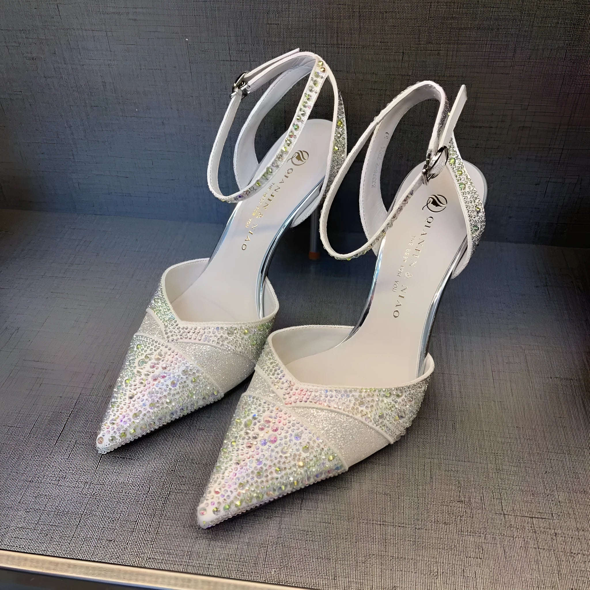Black women's hollow high heels with pointed toe, stiletto heel, and red sole on a plain background.