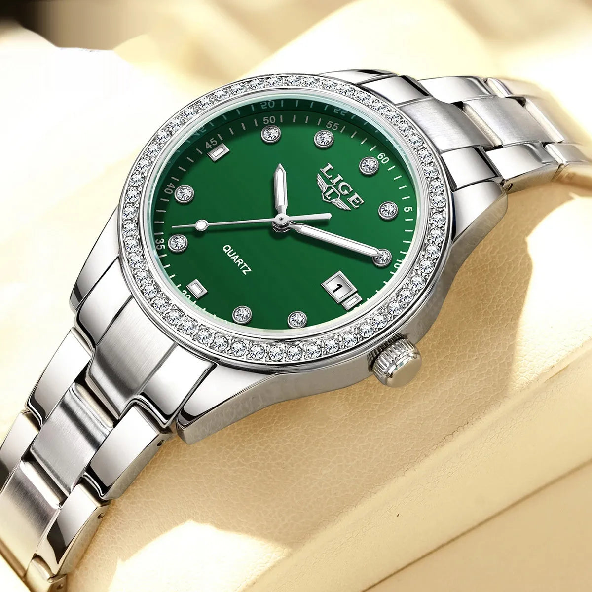 Silver fashion watch with diamond-encrusted round dial and luminous hands on a stainless steel strap.