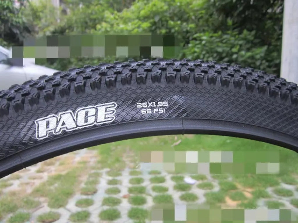 Ultralight black mountain bike tyre with white label sidewall option on a trail.