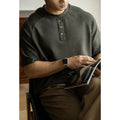 Casual loose-fitting grey pullover top with raglan sleeves and a textured terry fabric.