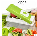 Green manual food chopper with stainless steel blades and plastic body on a kitchen worktop.