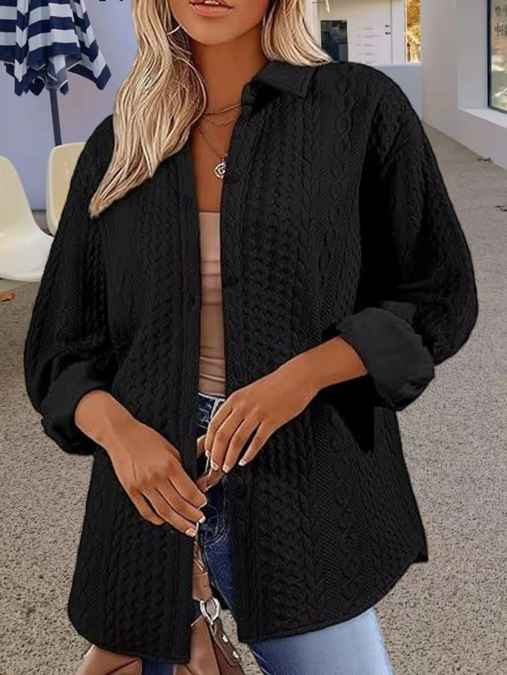 Women's solid colour long sleeve knitted cardigan in black shown on a hanger.