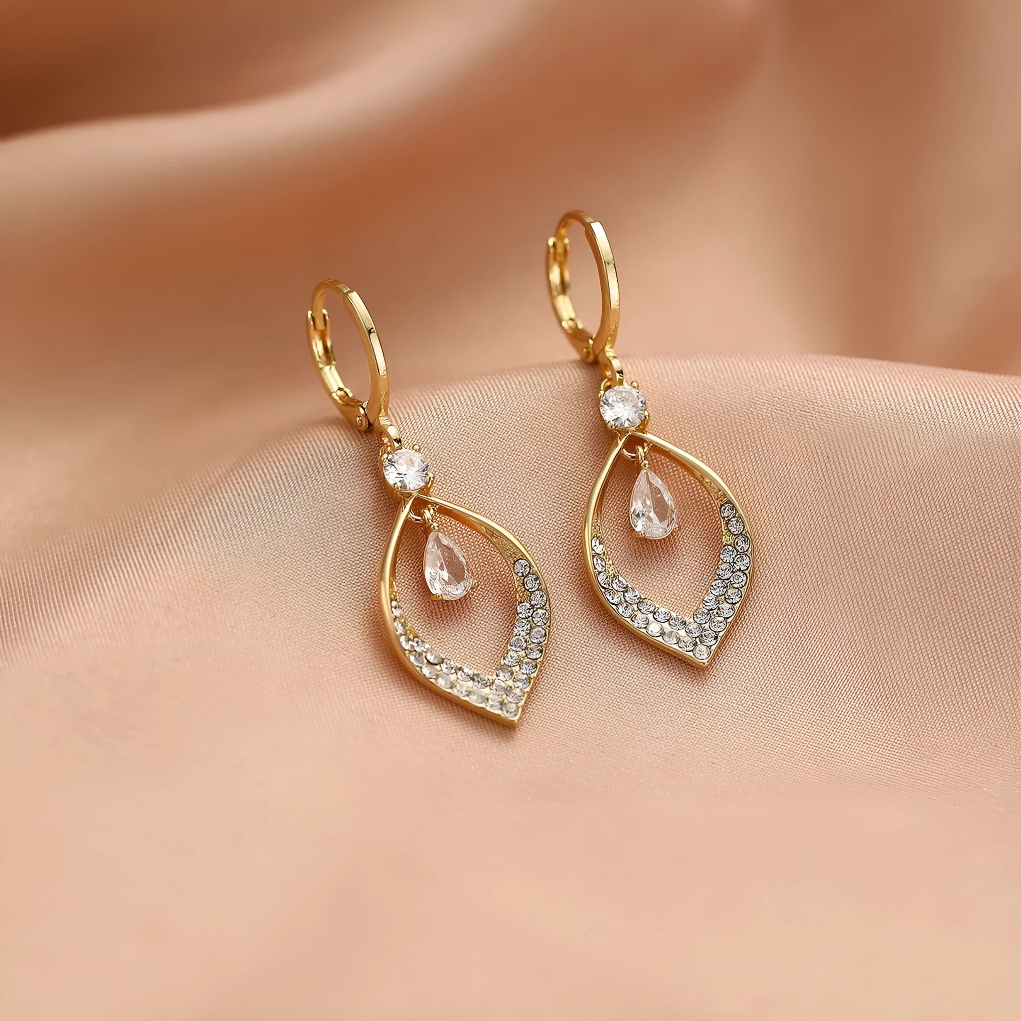 A pair of women's zircon teardrop tassel earrings with gold metal buckles on a white background.