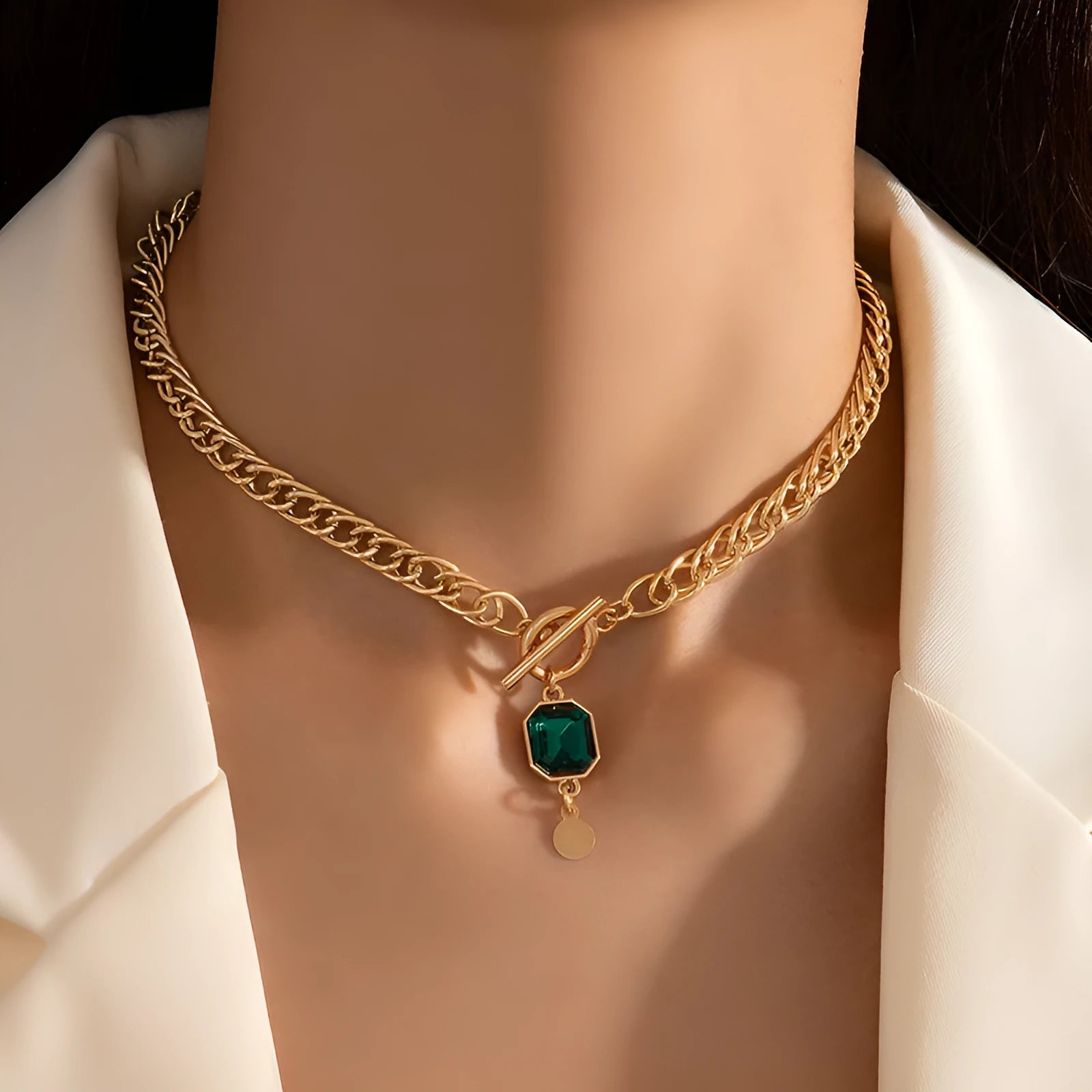 Gold electroplated geometric round pendant necklace with Cuban link chain and emerald zircon detail