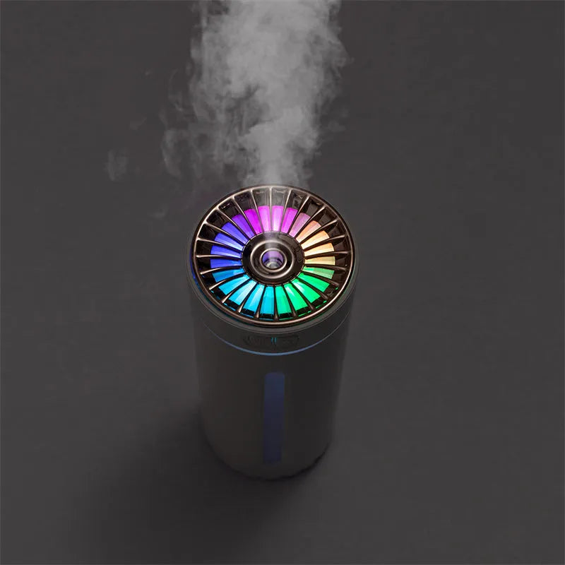 Black portable car humidifier with colourful LED lights on car cup holder showing mist output